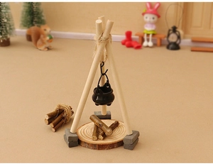 Miniature dollhouse tripod campfire set with hanging pot on a rustic wooden base