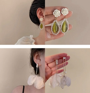 Detail of floral pearl drop earrings and rhinestone tassel charms on a model
