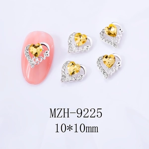 Nahaufnahme der 10mm silbernen Herz-Nagelkunst mit gelbem Stein und Love-Design