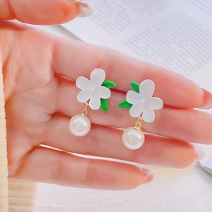 Detailed view of handmade tulip floral earrings with white petals and pearl drops