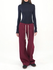 Detail of slim-fit tencel wool turtleneck paired with wide-leg trousers and drawstrings