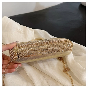 Detailed macro view of the sparkling rhinestone surface and golden chain of this luxury clutch bag