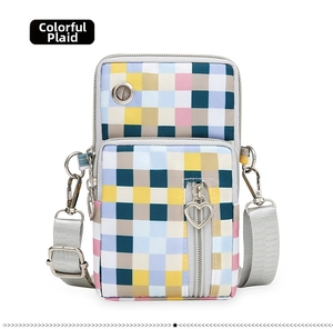 Detail of colorful plaid nylon crossbody phone bag with earphone port and heart zippers