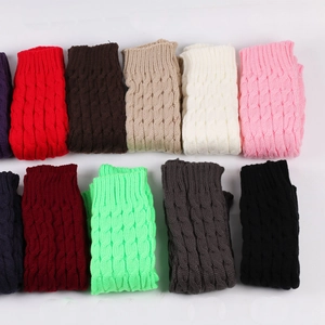 Flat lay display of knit leg warmers in various colors featuring cable knit patterns