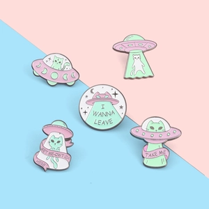 Détail de pin's émaillés chat extraterrestre et OVNI rose et vert menthe avec texte