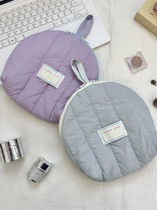 Quilted shell-shaped cosmetic bags in light purple and blue with zipper and wrist strap