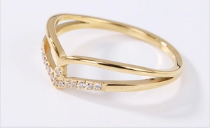 Macro shot of V-shaped gold ring with white zircon micro-inlay and polished finish