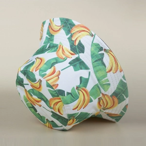 Close-up of tropical banana and green leaf print on a white cotton bucket hat