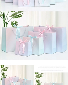 Detail of gradient pink and blue gift bags with ribbon handles and decorative bows
