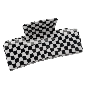 Minimalist checkered square hair claw clip in black and white pattern on white background