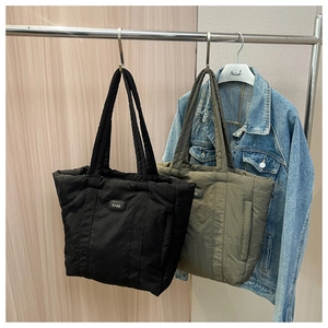 Detail of quilted tote bags in black and olive green showing spacious nylon texture
