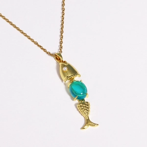 Detailed close-up of golden fish pendant featuring a turquoise gemstone and white pearl