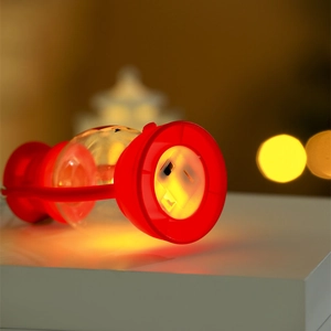 Detail of warm LED light and manual switch on the base of a red Christmas lantern