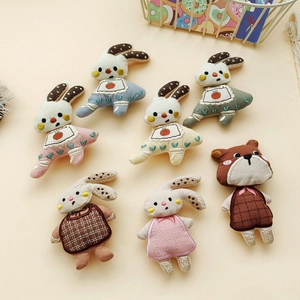 Detailed view of assorted embroidered fabric rabbit and bear doll accessories for DIY crafts