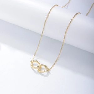 Dettaglio di anelli ovali intrecciati e lisci su una collana in argento S925 dorato
