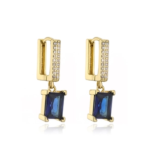 Detail of 18K gold geometric earrings with emerald-cut blue stones and small zircons