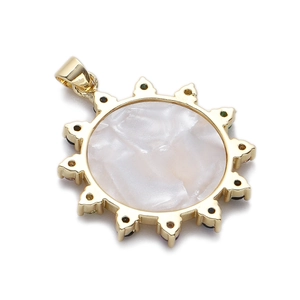 Macro d'un pendentif soleil doré avec nacre blanche et accents de gemmes sombres