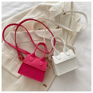 Detailaufnahme der Mini-Handtaschen aus PU-Leder in Rosarot und Weiß auf einem Blazer