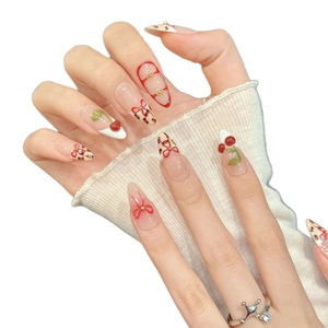 Sweet cherry and leopard print press-on nails with red bow and heart accents on long oval tips