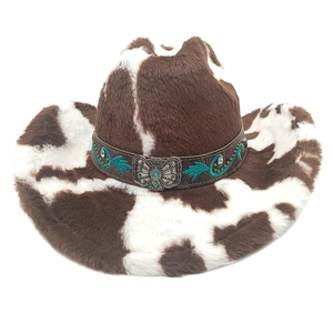 Détail du chapeau de cowboy à motif vache avec boucle papillon et turquoise gravée
