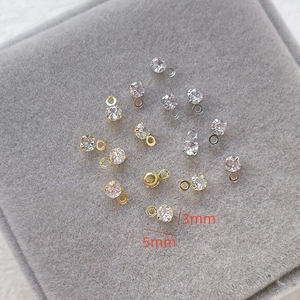 Macro detail of 3mm zircon pendants in gold and silver for DIY jewelry making