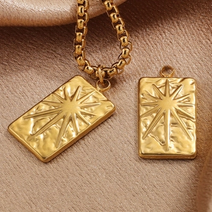 Detailed macro of 18K gold plated tarot sun star pendant on a chunky square link chain