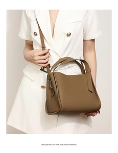 Brown leather bucket bag styled with a white blazer dress for a minimalist look