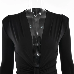 Détail d'une robe noire élégante avec col en V profond et design à nœud torsadé raffiné