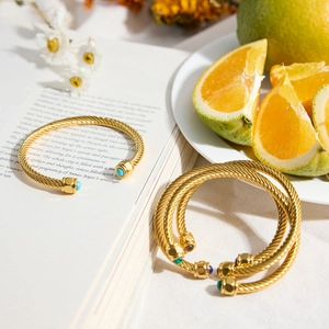 Detailed view of gold twisted rope bangle with green malachite stone in a lifestyle setting