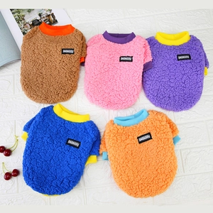 Flat lay of colorful pet fleece sweatshirts in five colors on a textured white background