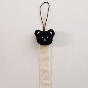 Detail of plush bear ornament and beige herringbone woven ribbon for hair accessory storage