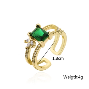 Close-up of 18K gold plated ring with emerald-cut green zircon and hollow double-band detail
