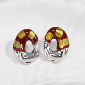 Detail of red and silver French vintage earrings with gold specks on white cloth