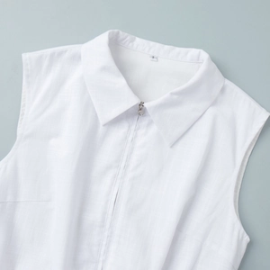 Close-up of white sleeveless vest top with lapel collar and zipper detail in cotton linen