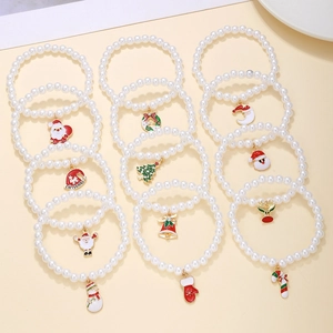 Detail of Christmas faux pearl bracelets with festive Santa and tree charms in red and gold