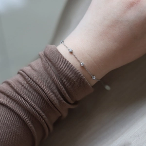 Close-up of a silver titanium steel bracelet featuring four sparkling round cubic zirconia