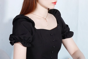 Detailed view of an elegant shell-inlay key pendant necklace on a chic square neck blouse
