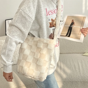 Detail of soft beige checkered plush texture on a large capacity crossbody bucket bag