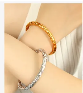 Detail of gold and silver stainless steel bangles with hammered liquid metal texture
