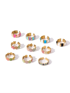 Detail of 18k gold plated open rings set featuring colorful enamel flowers and stripes