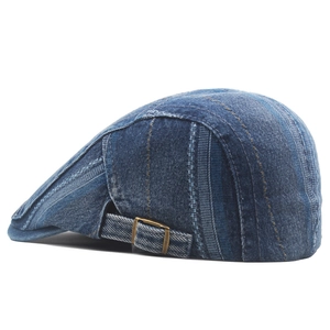 Close-up of washed denim ivy cap featuring contrast stitching and bronze metal side buckle