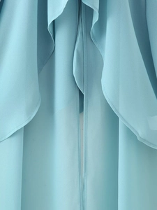 Close-up of light blue chiffon fabric showing delicate ruffles and sheer texture details
