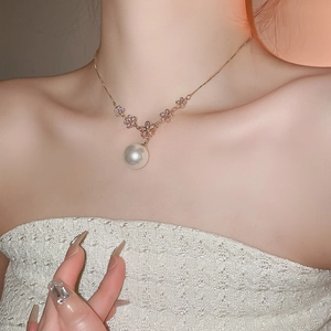 Close-up of pink zircon floral necklace with a large white pearl drop pendant