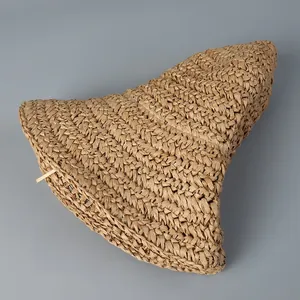 Detailed close-up of foldable paper straw sun hat showing portability and weave texture