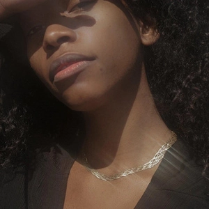 Detailed view of layered gold braided metal necklace draped on a model neck