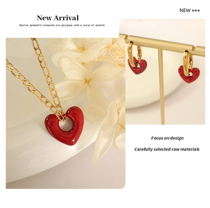 Detail of red hollow heart jewelry set with gold-plated Figaro chain and earrings