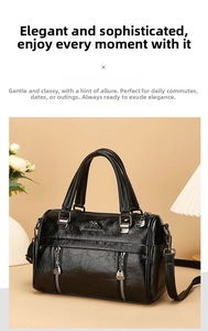 Detailed view of the soft black leather Boston bag with dual handles and metal logo