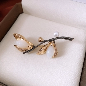 Detailed close-up of vintage branch brooch with pearls and diamonds on white leather