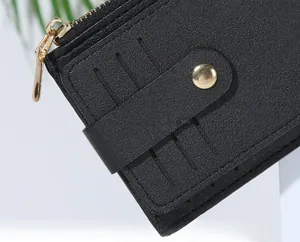 Detail of black PU leather card holder with gold zipper and snap button on white stand