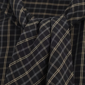 Detailed view of the plaid fabric texture with black and beige windowpane check pattern